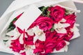 Bouquet of red roses and white orchids with blank note. Present gift for holiday. Space. Valentine`s day flowers Royalty Free Stock Photo