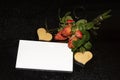 Bouquet of red roses, wooden heart and a blank piece of paper