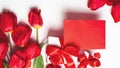 Bouquet of red tulips, envelope, gift box, on a white background. Valentine`s Day greeting card. Copy space. Top view Royalty Free Stock Photo