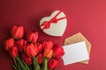 Bouquet of red  tulips and gift heart box isolated on red background . Spring flowers. Greeting card for Birthday, Woman, Mother` Royalty Free Stock Photo