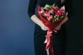 Bouquet of red tulips in girs hands. Unrecognisable.