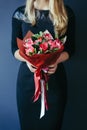 Bouquet of red tulips in girs hands. Unrecognisable.