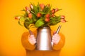 Bouquet of red tulips in a metal vase. Woman holding flowers in her hands Royalty Free Stock Photo