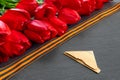 Bouquet of red tulips with in pile of old letters on black granite background for the Victory Day Royalty Free Stock Photo