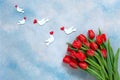 Bouquet of red tulips and white dove figurines with red heart. Concept for Valentine`s Day, womens day and other romantic events