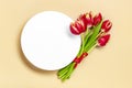 Bouquet of red tulips, white podium on beige background Top view Flat lay Holiday greeting card Happy moter's Royalty Free Stock Photo