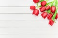 Bouquet of red tulips on white wooden background. Mothers day, Valentines Day, Birthday celebration concept. Copy space, top view