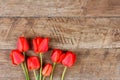 Bouquet of red tulips on wooden retro grunge background with copy space Royalty Free Stock Photo