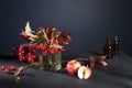 A bouquet of red viburnum branches with ripe berries in a vase stands on the table opposite the dark blue wall Royalty Free Stock Photo