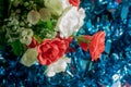 Bouquet of red and white artificial flowers on blue background. Selective focus Royalty Free Stock Photo