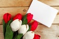 Bouquet of red and white craft paper tulips and white mockup blak on wooden background.