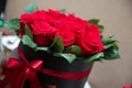 A bouquet of red and white roses in a red round box .Flower bouquet made of red roses, dark red carnations, black berries and Royalty Free Stock Photo