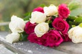 Bouquet of red and white roses on a wooden table in the garden Royalty Free Stock Photo