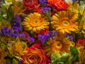 a bouquet of red, yellow and blue flowers with dew drops