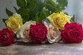 Bouquet of red, yellow and cream roses. On a wooden background, which stand on the windowsill. Window. Summer flowers Royalty Free Stock Photo