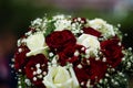 Bouquet of roses in bride hands. Weddind details in closeup viewwith blurred background. Solemn event