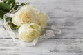 Bouquet of roses decorated with lace on white wooden background Royalty Free Stock Photo