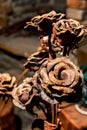 A bouquet of roses, forged by a blacksmith from metal, stands in a blacksmith\'s workshop.
