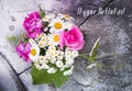 Bouquet of roses, geranium, daisies on a concrete wall with a crack