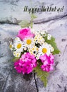 Bouquet of roses, geranium, daisies on a concrete wall with a crack