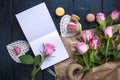 A bouquet of roses is pink, in gray paper and a white heart. Rose on an open notebook. Sweet pasta macaroons of different colors, Royalty Free Stock Photo