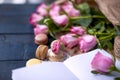 A bouquet of roses is pink, in gray paper and a white heart. Rose on an open notebook. Sweet pasta macaroons of different colors, Royalty Free Stock Photo
