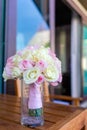 A bouquet of roses, in a vase, on the table, looking fresh and beautiful, with pink and yellow flowers. Royalty Free Stock Photo