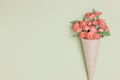 Bouquet of small red roses in vintage paper on the table. Royalty Free Stock Photo