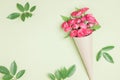 Bouquet of small red roses in vintage paper on the table. Royalty Free Stock Photo