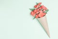 Bouquet of small red roses in vintage paper on the table. Royalty Free Stock Photo