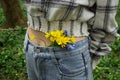 Bouquet of small yellow flowers on a woman`s belt. First spring flowers Royalty Free Stock Photo