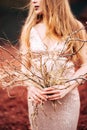 Portrait of a bride model in a golden wedding evening dress, in a yellow-red sandy quarry, in the crater of a volcano in