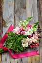 Bouquet of snapdragon (Antirrhinum majus) on vintage wooden boar