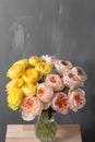 Bouquet of soft pink and yellow garden roses in a glass vase. Floral still life. Royalty Free Stock Photo