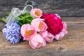 Bouquet of spring flowers decorated with ribbon on old wooden table