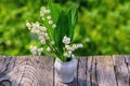 Bouquet of spring flowers standing in a vase on a wooden table with copy space.Lily of the valley. Royalty Free Stock Photo