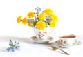 Bouquet of spring flowers. Still life of dandelions, forget-me-nots and cups of tea. Isolated on white background