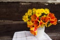 A bouquet of spring flowers in a white vase on a blurry wooden background Royalty Free Stock Photo
