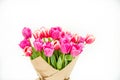 Bouquet of spring pink tulips wrapped in paper for a gift isolated on a white background Royalty Free Stock Photo