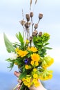 Bouquet of spring wildflowers in a hand against a blue sky background Royalty Free Stock Photo