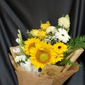 A bouquet with sunflowers, yellow roses, gerberas and another white flower Royalty Free Stock Photo