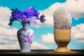 Bouquet and surrealistic eggs on a blue sky