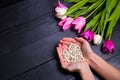 Bouquet of tender pink tulips and hands holding pearl necklace o Royalty Free Stock Photo