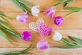 Bouquet of tender pink tulips with wicker hearts on light wooden Royalty Free Stock Photo