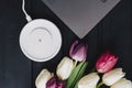 A bouquet of tulips, a laptop and a wireless smartphone charger.