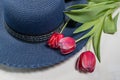 Straw hat and bouquet of pink tulips