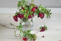 Bouquet of twigs with red ripe lingonberries in a glass. copy space, mock up, text.