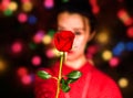 A red valentines rose holding by a girl.