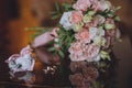 Wedding bouquet of white and pink roses. Bouquet, boutonniere and two rings of the newlyweds are on the glass table Royalty Free Stock Photo