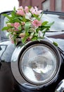 Bouquet for a wedding ceremony lying on a headlight of an old retro car Royalty Free Stock Photo